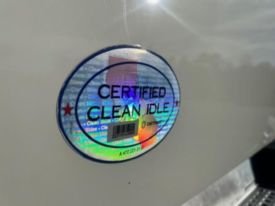 Sticker on vehicle showing 'CERTIFIED CLEAN IDLE' with holographic background.