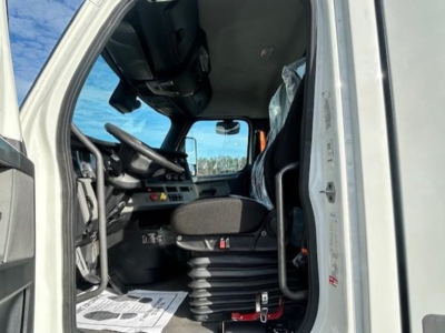 Truck cab interior of a 2021 Freightliner Cascadia 126 day cab showing steering wheel, dashboard, and driver's seat with clutter-free controls.