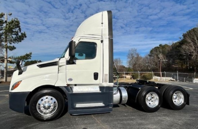 Truck side view of 2021 Freightliner Cascadia 126 day cab tractor showing sleeper, front fender, and dual rear axles.