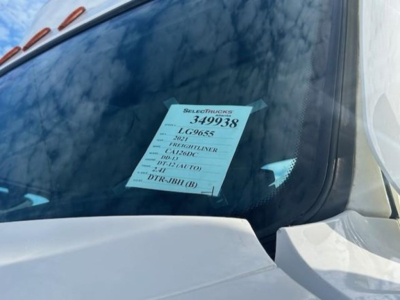Truck windshield with a data sheet visible on the passenger side window, listing stock number 349938 and various codes.