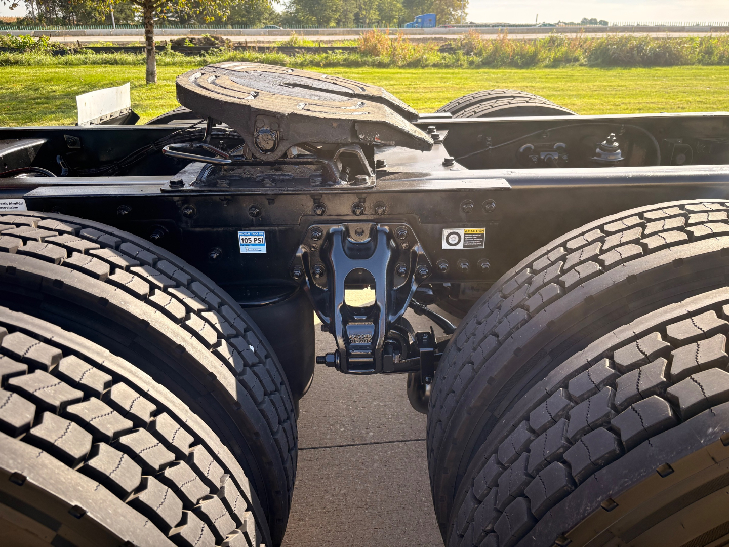 Kenworth T680 chassis with dual rear axles and fifth wheel area visible, showing wheel tires and undercarriage components.
