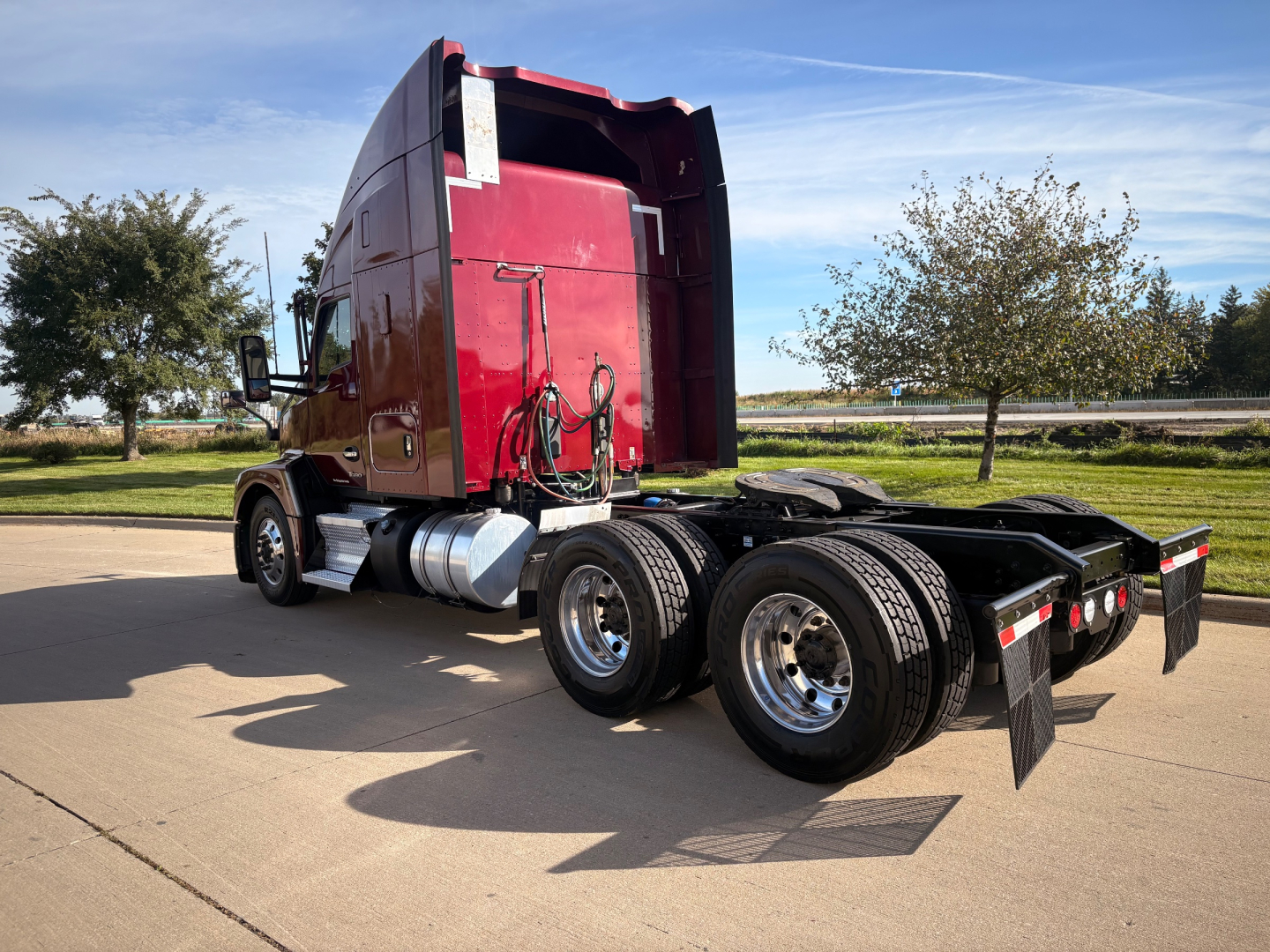 Kenworth T680 tractor rear-side view showing sleeper, fuel tanks, and dual rear axles with mudflaps.