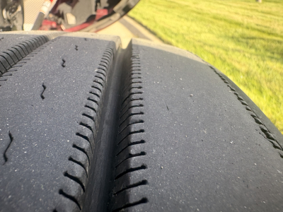 Kenworth T680 truck wheel and tire close-up; tread detail visible; part of the truck's drive tire area with some surface dust.