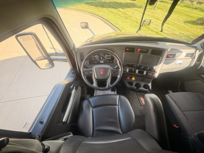 Kenworth T680 interior cabin view from driver seat showing steering wheel dashboard and center console.