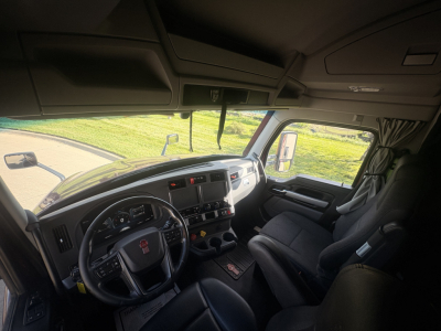 Kenworth truck interior showing dashboard and steering wheel with a grey interior; visible are instrument cluster, center console, and driver seat.