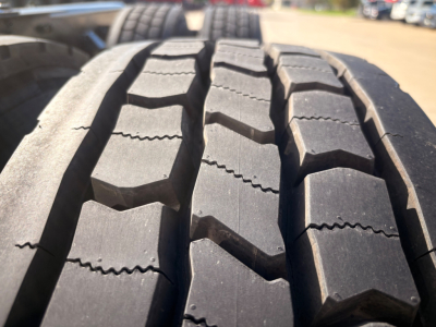 Tire tread close-up on Kenworth T680 pickup showing large block tread pattern