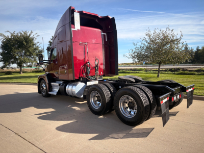 Kenworth T680 tractor rear-side view showing sleeper, fuel tanks, and dual rear axles with mudflaps.