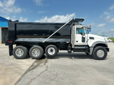 Dump truck side view showing Mack GR64F with black dump body and front white cab, six wheels visible, VIN 1M2GR4GC9LM019926 and stock B3430P.