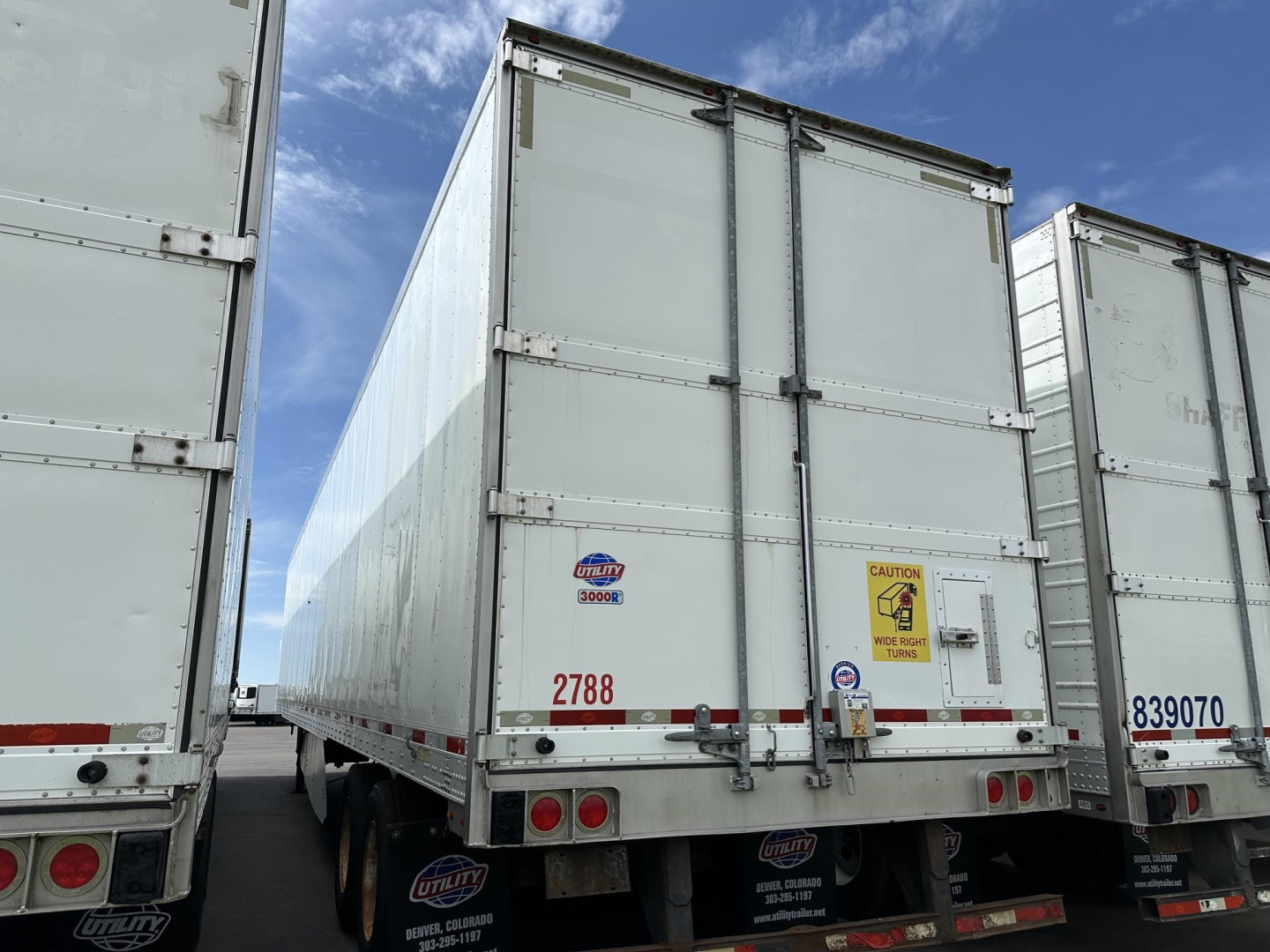 Rear view of a used 2018 Utility 3000R reefer trailer showing double rear doors, tail lights, bumper, and safety decals.