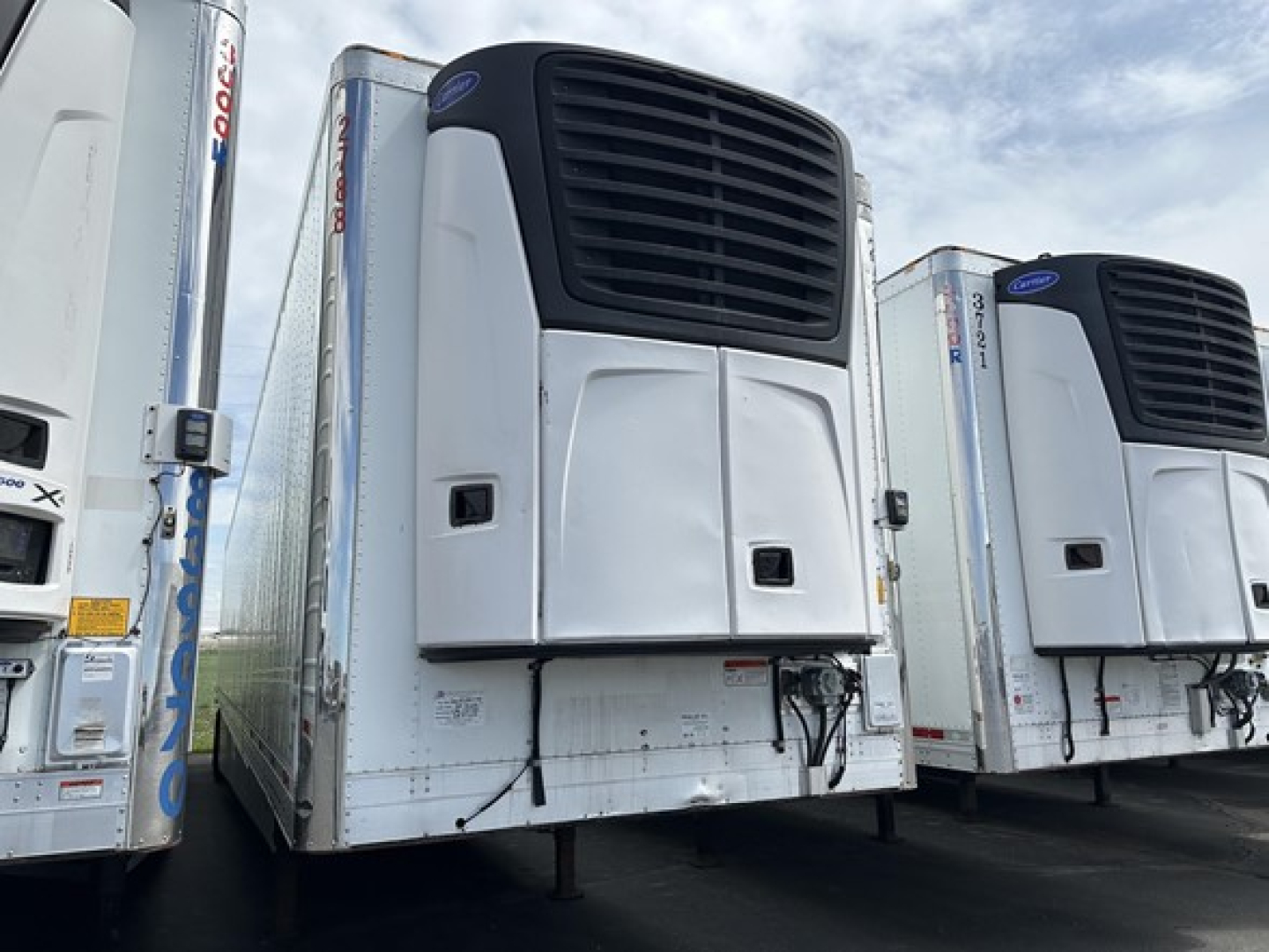 Utility 3000R trailer with reefer unit mounted at front, white body, black grille, parked among similar trailers.