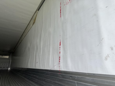 Trailer interior wall with white insulated paneling and ribbed steel floor edge, part of a 2018 Utility 3000R reefer trailer.
