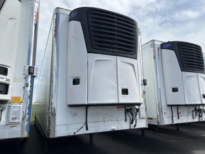 Utility 3000R trailer with reefer unit mounted at front, white body, black grille, parked among similar trailers.