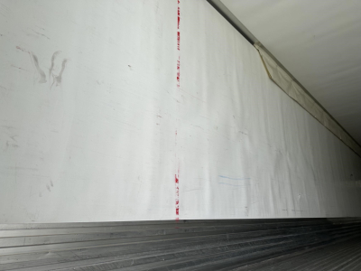 Trailer interior side wall withWhite aluminum surface and ribbed floor edge.
