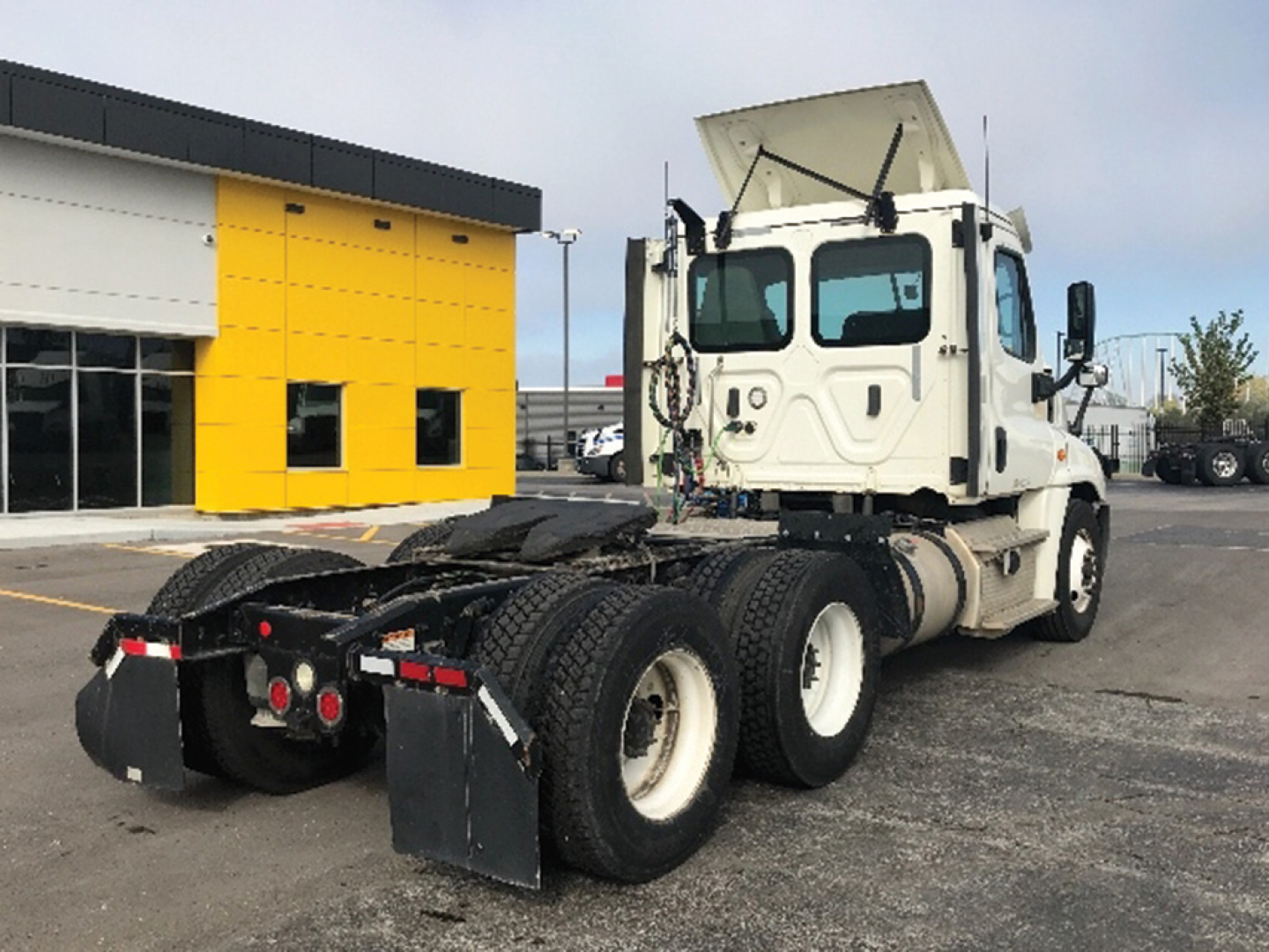 Freightliner Cascadia125 tractor rear/side view showing sleeper cab, dual rear axles, and fifth-wheel with mudflaps.
