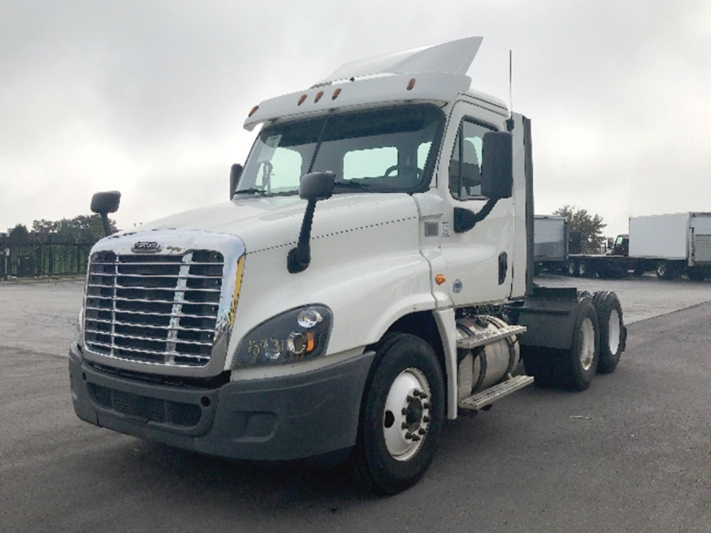 Truck cab showing Freightliner Cascadia125 with front grille, headlights, large side mirrors, and dual rear axles. Visible are the white tractor and chrome bumper.