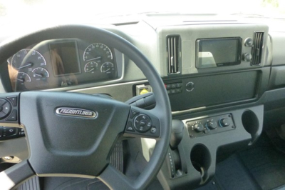 Freightliner M2 106 cab interior showing steering wheel and dashboard controls