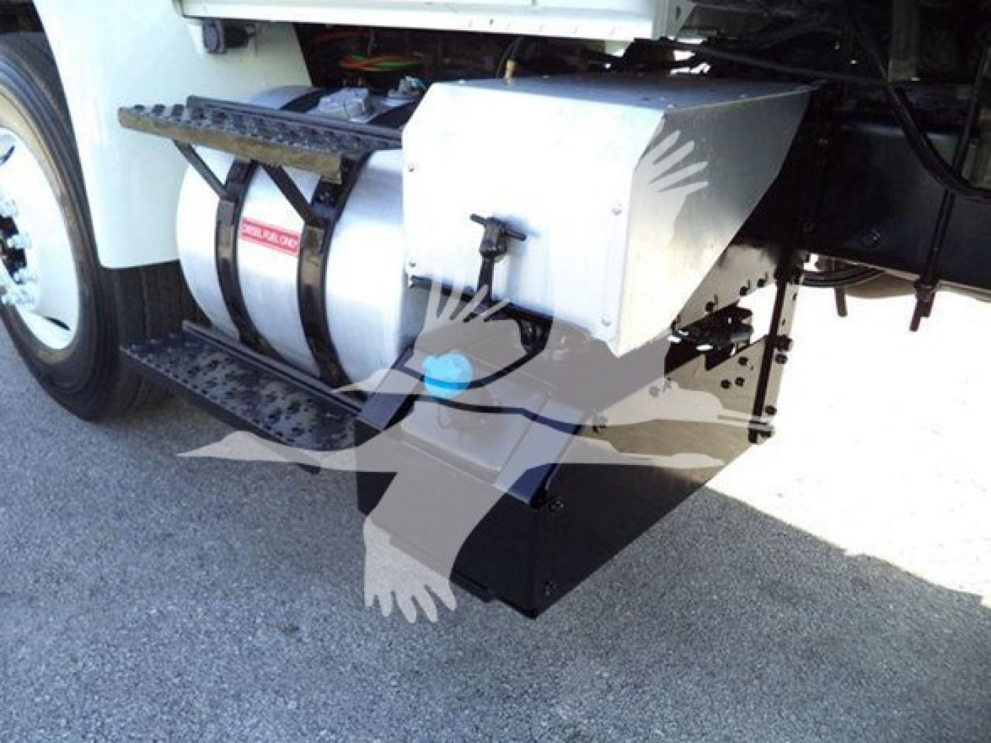 Truck side showing fuel tank and underbody equipment near the cargo area.