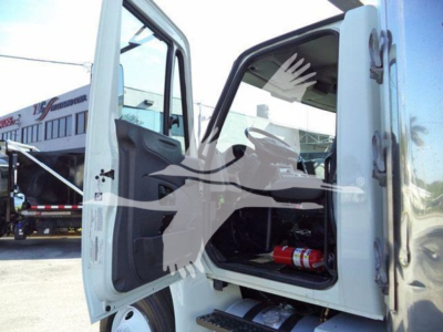 Interior cab of a 2019 International Durastar 4300 refrigerated truck with doors open; visible is a fire extinguisher in the cabin and part of the cab interior.