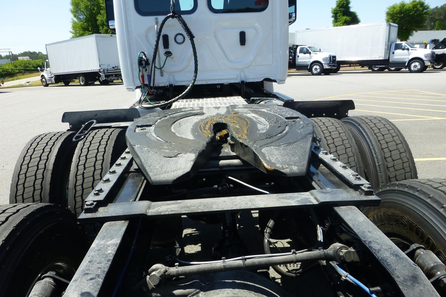 Rear view of a Freightliner Cascadia tractor chassis showing fifth wheel mounting and rear axles with dual tires.