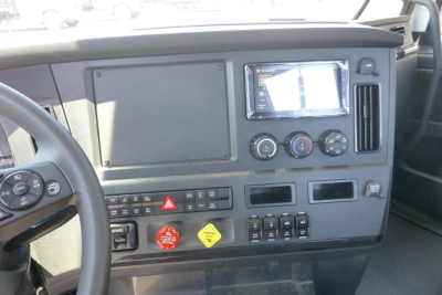 Freightliner Cascadia dashboard and steering wheel showing instrument panel, controls, and a touchscreen display.