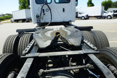 Rear view of a Freightliner Cascadia tractor chassis showing fifth wheel mounting and rear axles with dual tires.