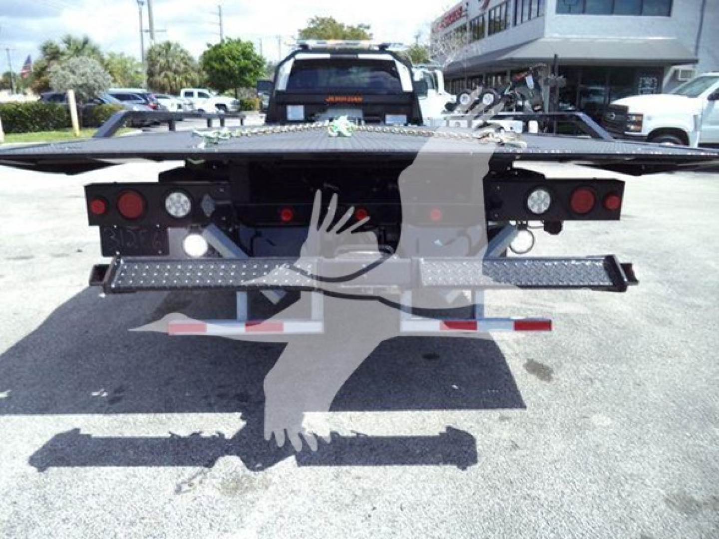 Ram 5500 rollback truck rear view showing loading ramps and warning lights.