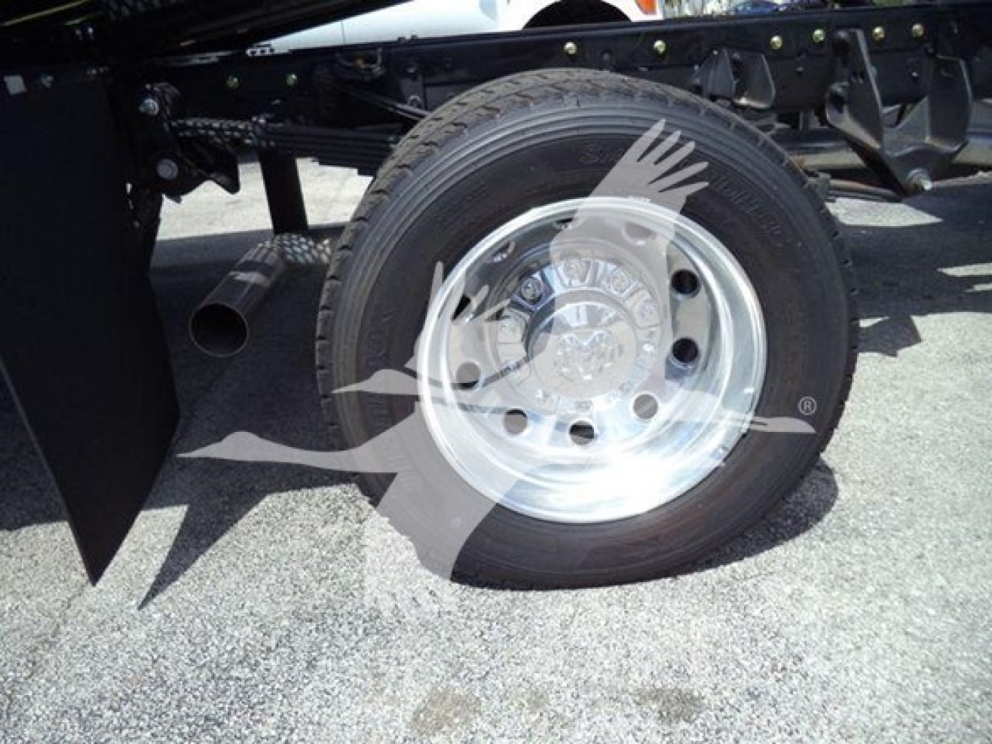 Wheel and suspension area of a Ram 5500 truck showing a polished steel rim, tire, and part of the rollback chassis.