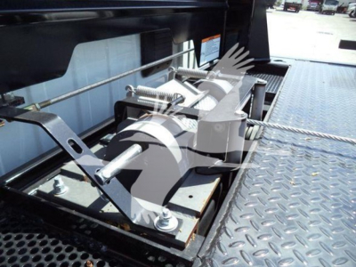 Ram 5500 rollback tow arm mechanism on truck bed showing steel components and mounting bolts