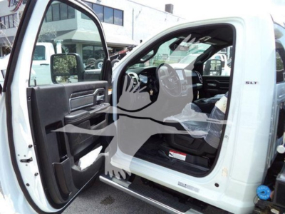 Ram 5500 SLT cab interior with door open, steering wheel and dashboard visible; white exterior; badge 'SLT' on doorway.