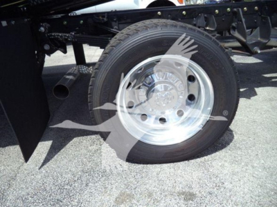 Wheel and suspension area of a Ram 5500 truck showing a polished steel rim, tire, and part of the rollback chassis.