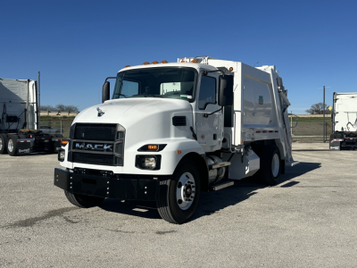 White Mack MD6 refuse truck angled front-left showing cab with chrome grille, black bumper, amber cab marker lights, and a large white rear compactor body.