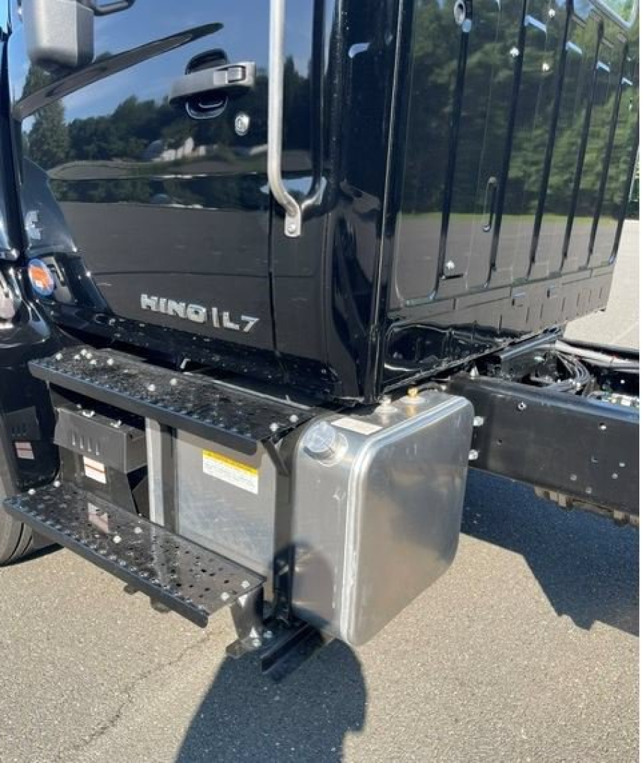 Hino L7 cab chassis truck side view showing cab, step, and small grey fuel/oil reservoir near the chassis with labels visible.