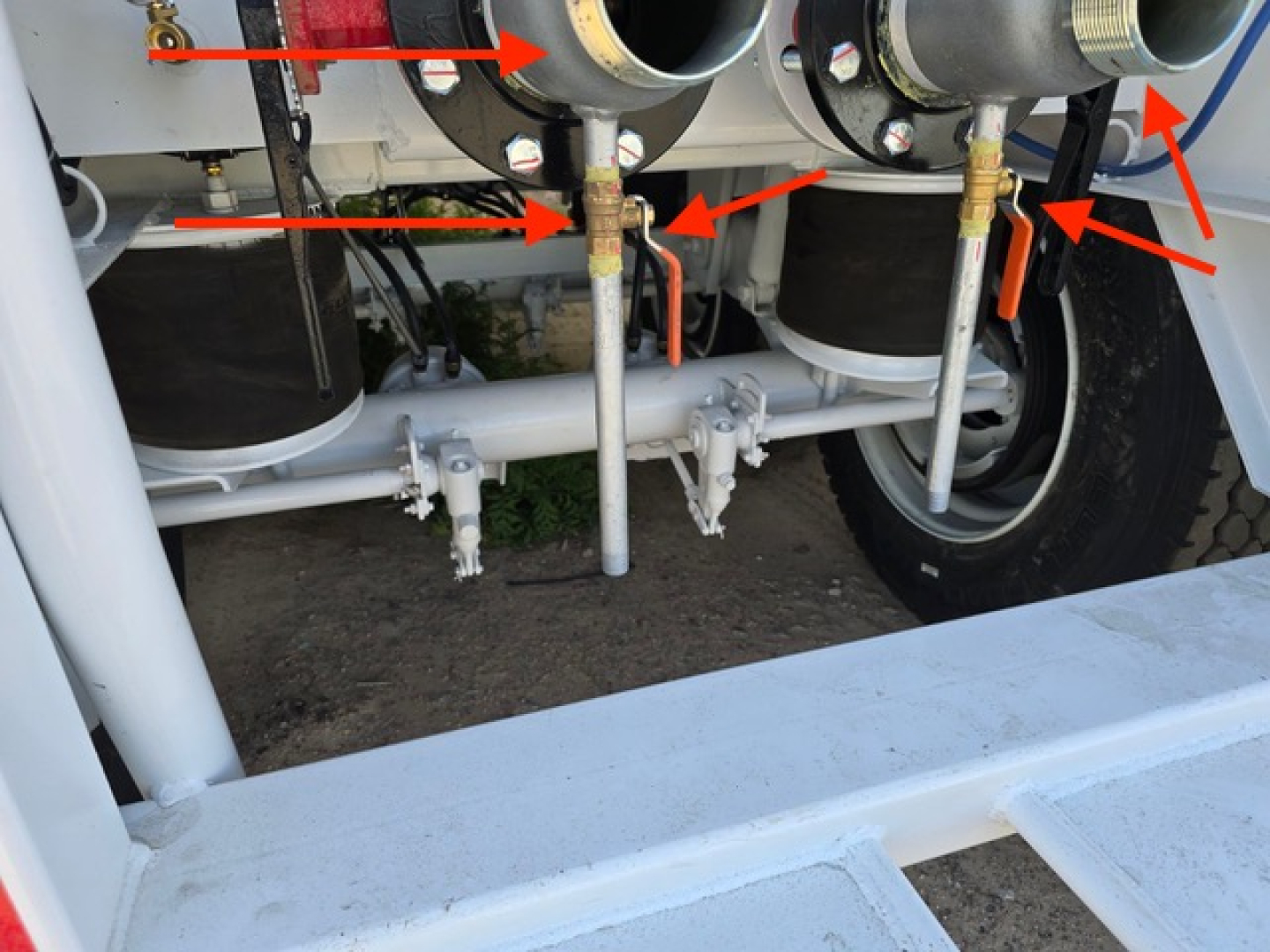 Trailer undercarriage showing gas lines, valves, and piping for a vacuum steel tank trailer with multiple hoses and brackets.