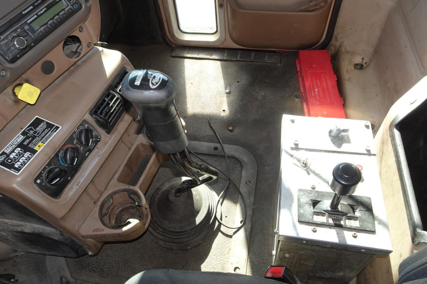 Cab interior of a 2005 Mack CV (Granite) dump truck showing gear shifter, instrument panel, and a secondary control console.