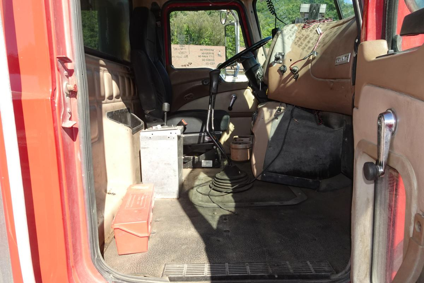 Truck cab interior showing Steering wheel, dashboard, and driver’s seat of a Mack CV (Granite) CV713 dump truck.