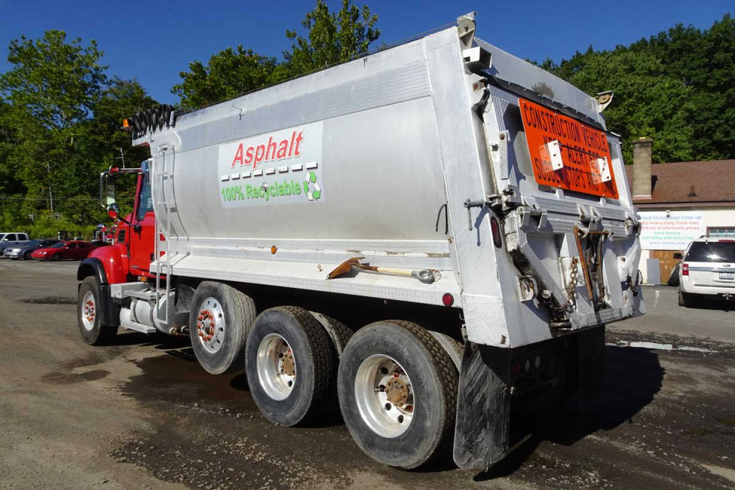 Mack CV (Granite) CV713 dump truck side view showing Asphalt logo and 100% recyclable label on silver dump body.
