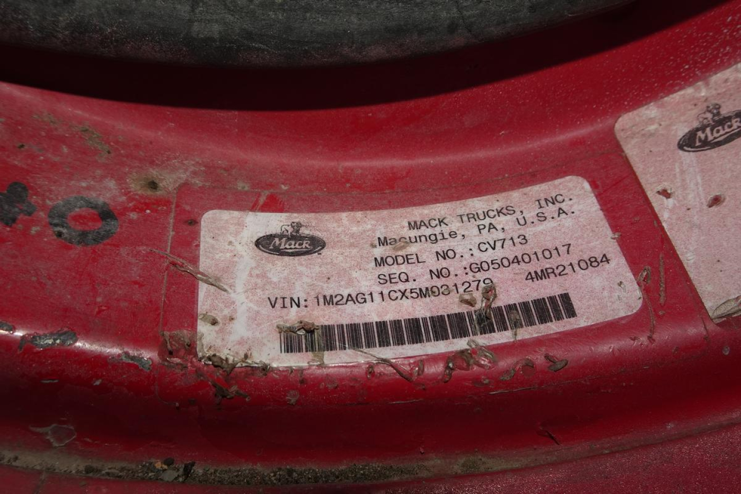 Mack Trucks label on red vehicle showing Mack Trucks, Inc. Maspungie? PA, U.S.A. model CV713, VIN: 1M2AG11CX5M031279, stock no. CV713, seq no. G050401017, MRQ?1084