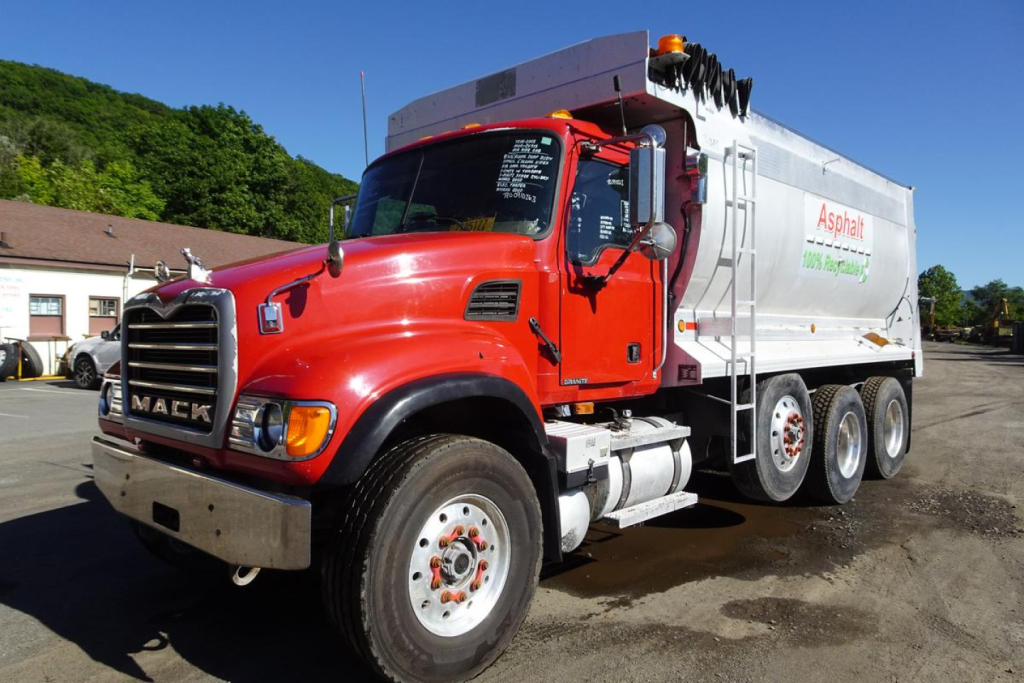 Mack CV Granite dump truck front-left view showing red cab and white dump body with Asphat logo, chrome grille, and large tires.