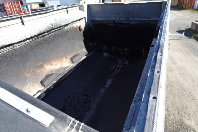 Dump truck bed showing interior with worn bed sides and dark, empty cargo area.