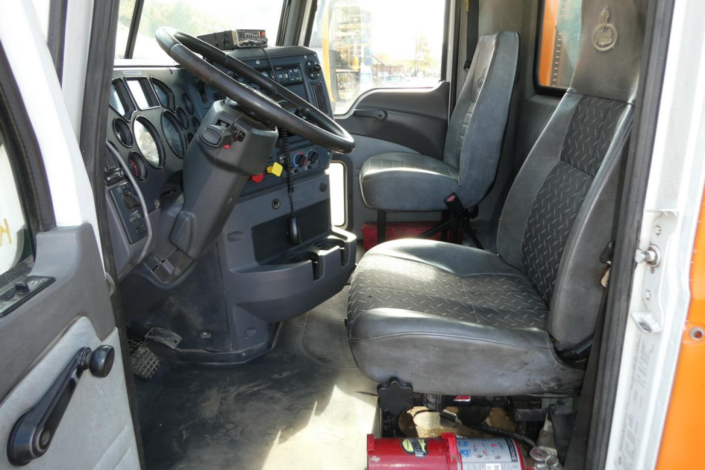 Truck cab interior showing steering wheel, driver's seat, and dashboard of a 2016 Mack CXU Pinnacle truck.