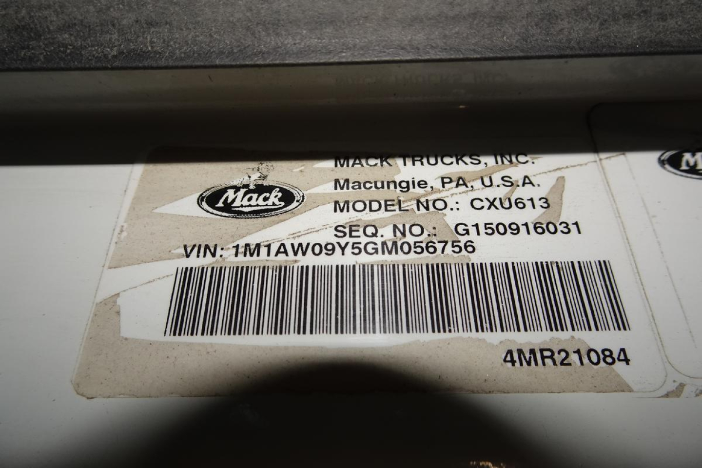 Mack CXU613 truck identification label showing Mack Trucks, Inc. tag with model CXU613, VIN 1M1AW09Y5GM056756, barcode, and QC/stock codes.