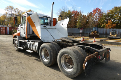 Truck chassis rear view showing cab, dual rear axles, and fifth wheel on a Mack CXU daycab.