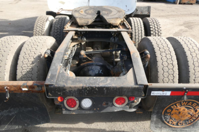 Rear view of a 2016 Mack CXU Pinnacle truck chassis showing dual rear axles, suspension, and frame with visible wheels and mud flaps.