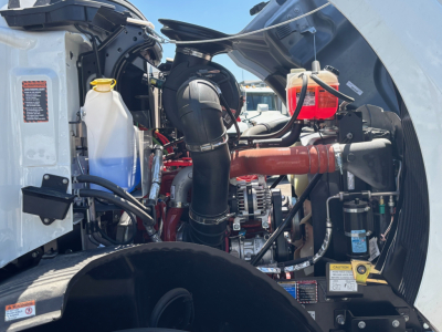 Mack MD6 engine bay with coolant reservoir, air intake, and various hoses; visible labels and components in front left quadrant.