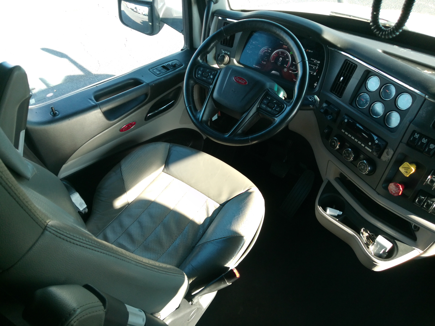 Peterbilt 579 cab interior showing steering wheel dashboard gauges and driver seat