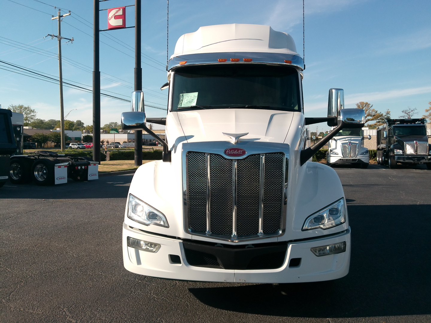 Peterbilt 579 truck front view in a dealership lot with chrome grille, large mirrors, and daytime running lights.