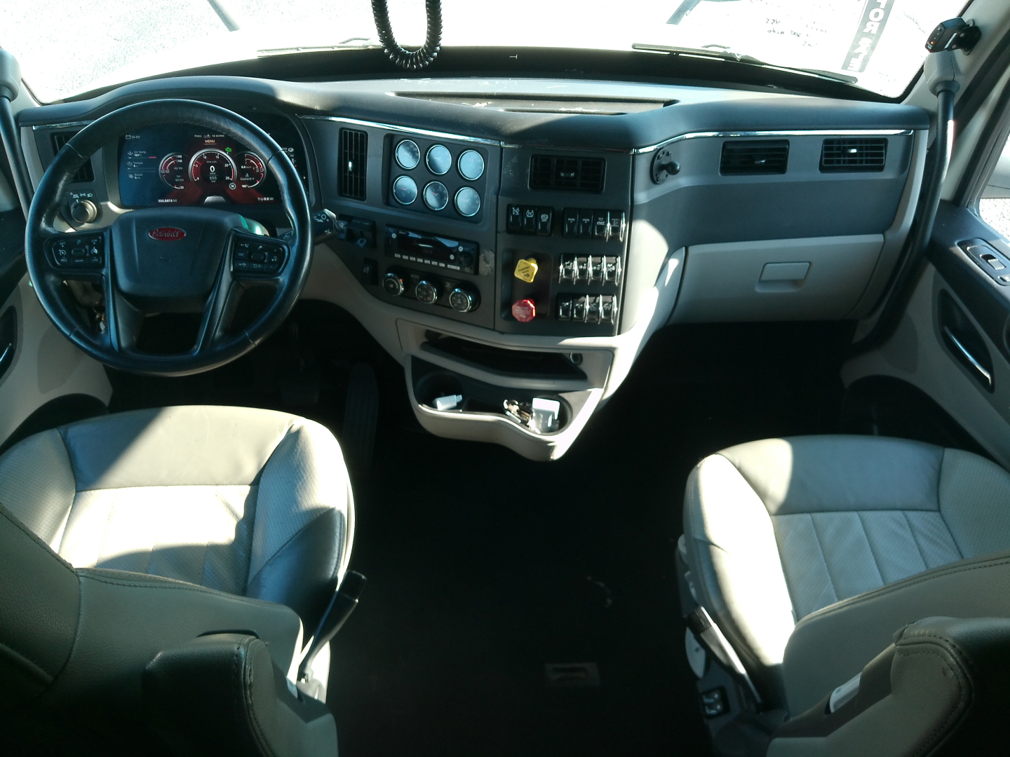 Peterbilt 579 interior with steering wheel, dashboard cluster, and center console; visible gauges and controls.