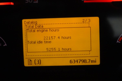 Dashboard display showing total engine hours 22157.4 and total idle time 5255.1 hours, odometer 634798.7 mi, and Datatag page 2/3.