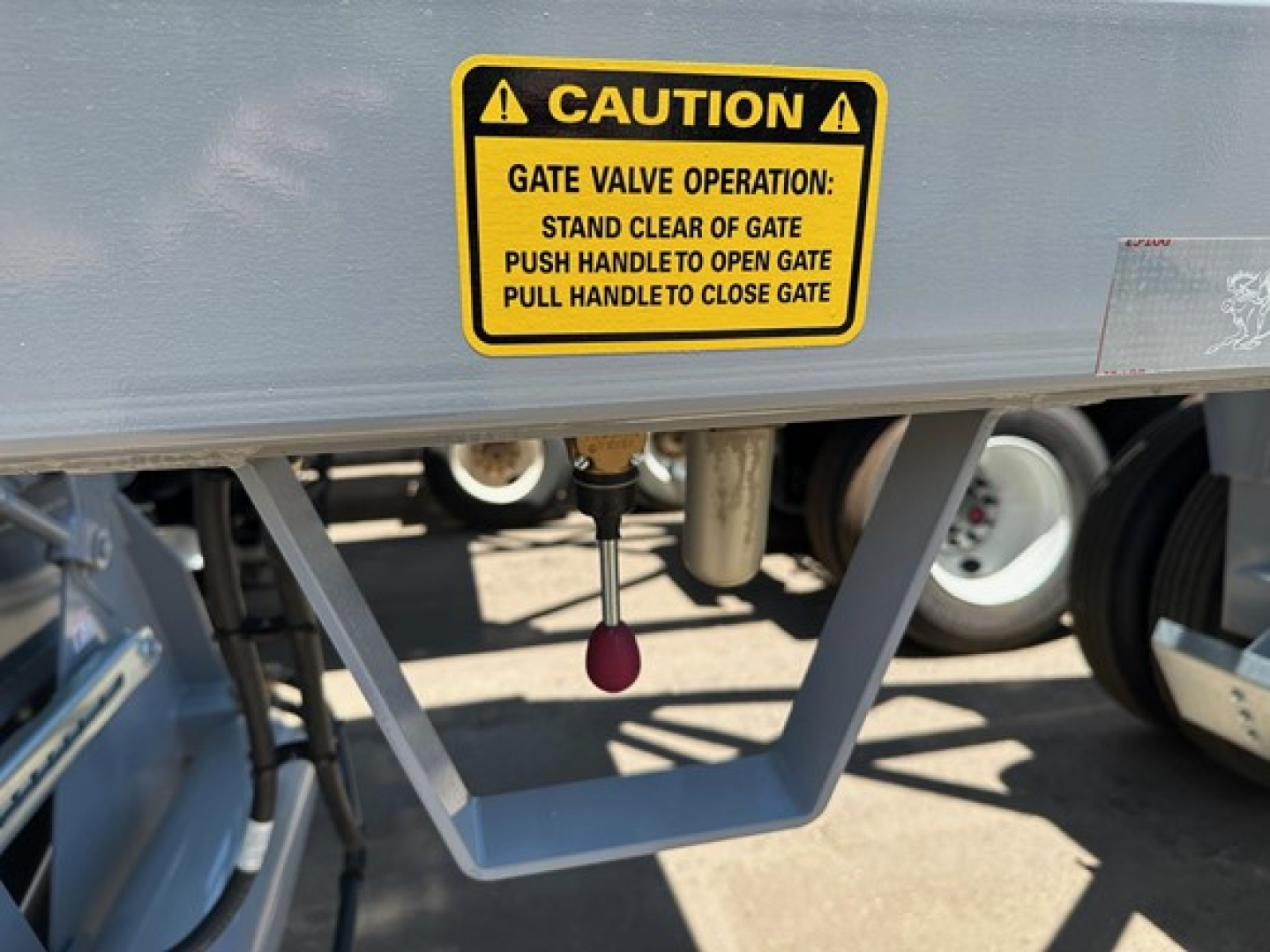 CPS light weight bottom dump trailer showing warning label and gate valve caution sticker.