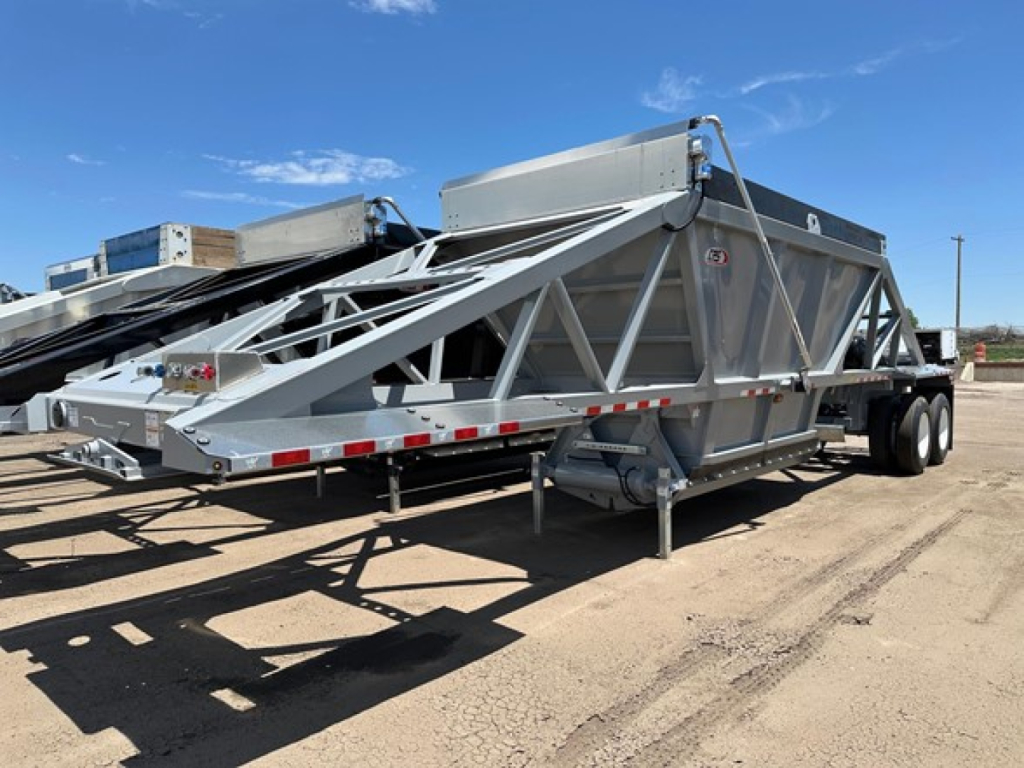 Bottom dump trailer showing lightweight cps design with triangular truss frame and dual-axle configuration.